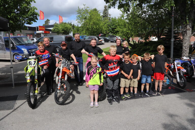 Jane Grosberghaugen, Eivind Halle og Solvår Taugbøl backer de yngste medlemmene av motocrossklubben i Eidskog på utstilling i Skotterud sentrum under Gla'dagen.