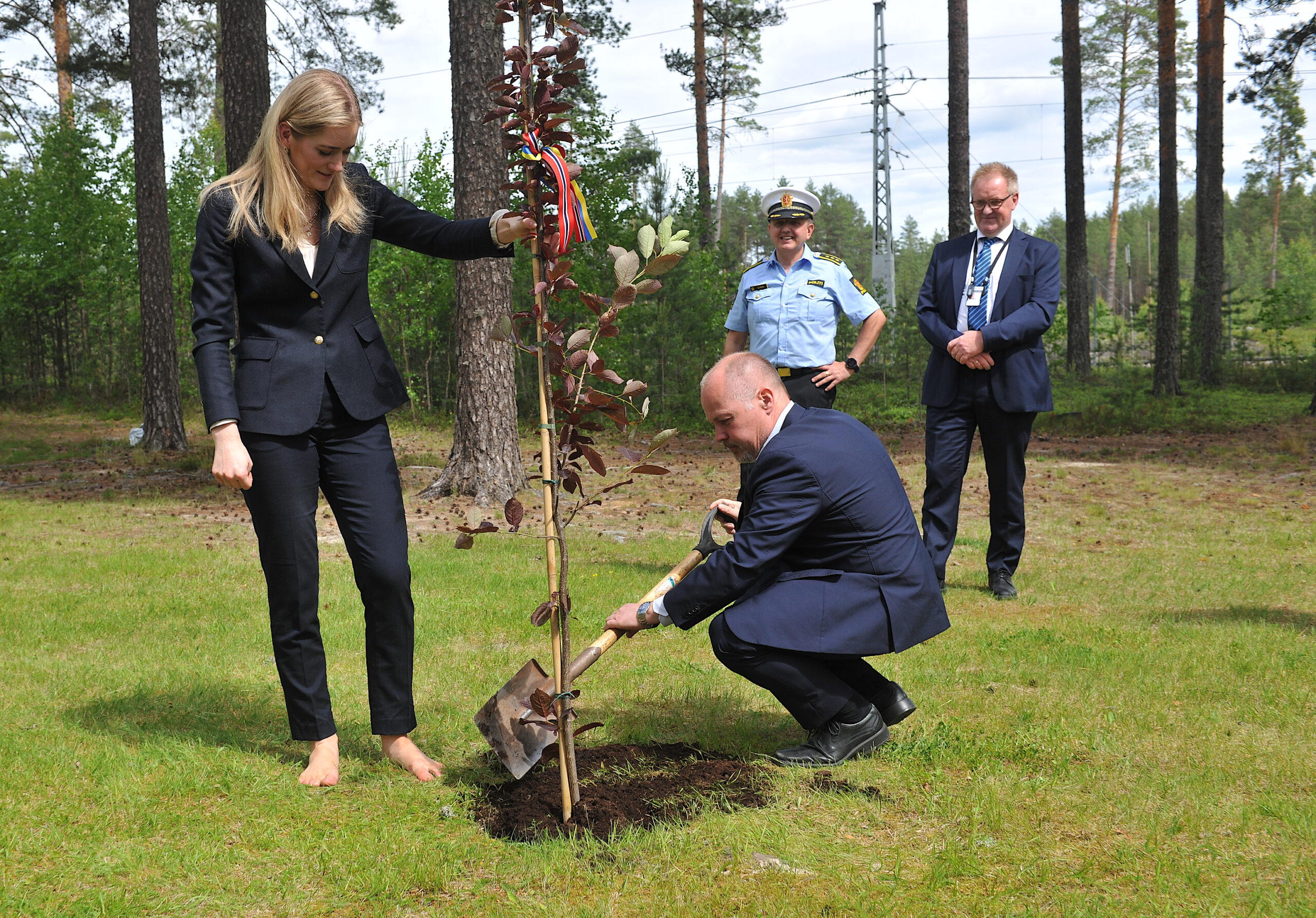 Sveriges justitie- och inrikesminister Morgan Johansson planter en hegg som det «svenske» treet i Minnelunden på Fredsplassen Morokulien med hjelp av en barbeint justis- og beredskapsminister Emilie Enger Mehl.