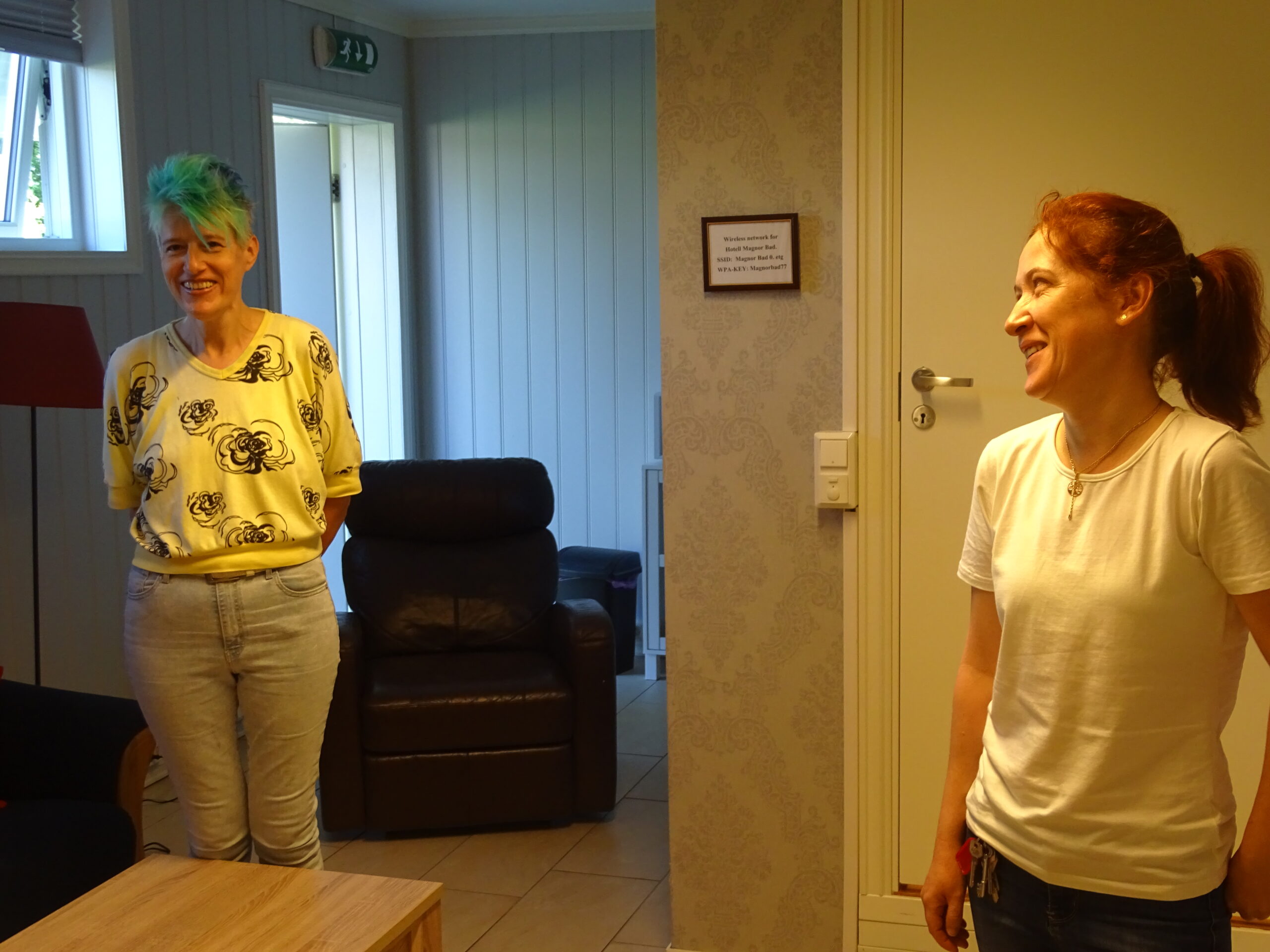 Marju Mikaelson og Oksana Nilsen på det største hotellrommet på Magnor Bad, med sittegruppe, fire senger og god plass.