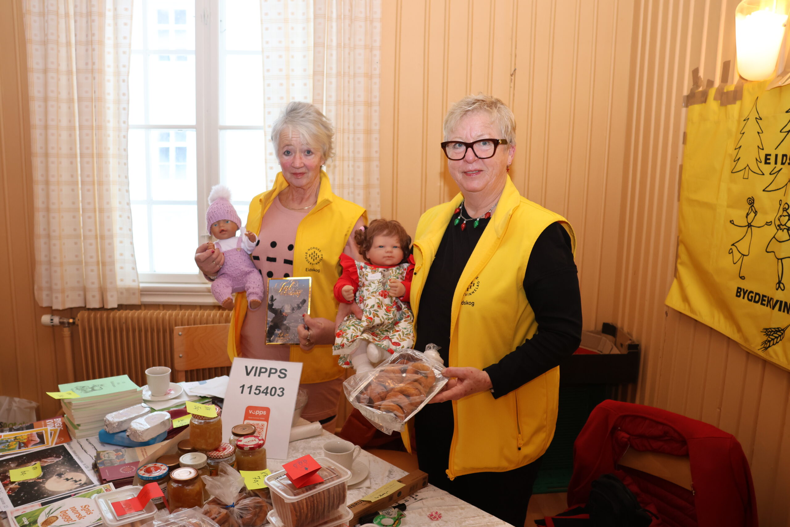 Randi Tukun Sanderud og Mariann Rundgren fra Eidskog bygdekvinnelag solgte julebakst på julemarkedet på Matrand.Med seg hadde dem to små maskoter utlånt av naboutstilleren.