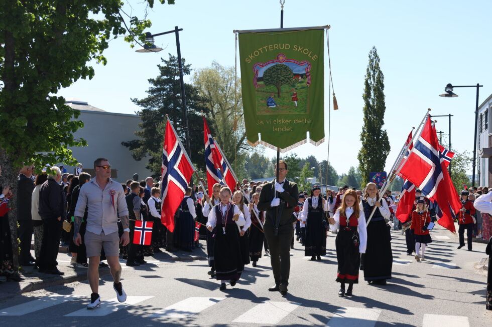 Et langt 17. mai tog beveget seg gjennom Skotterud sentrum med Skotterud skoles fane aller først.
