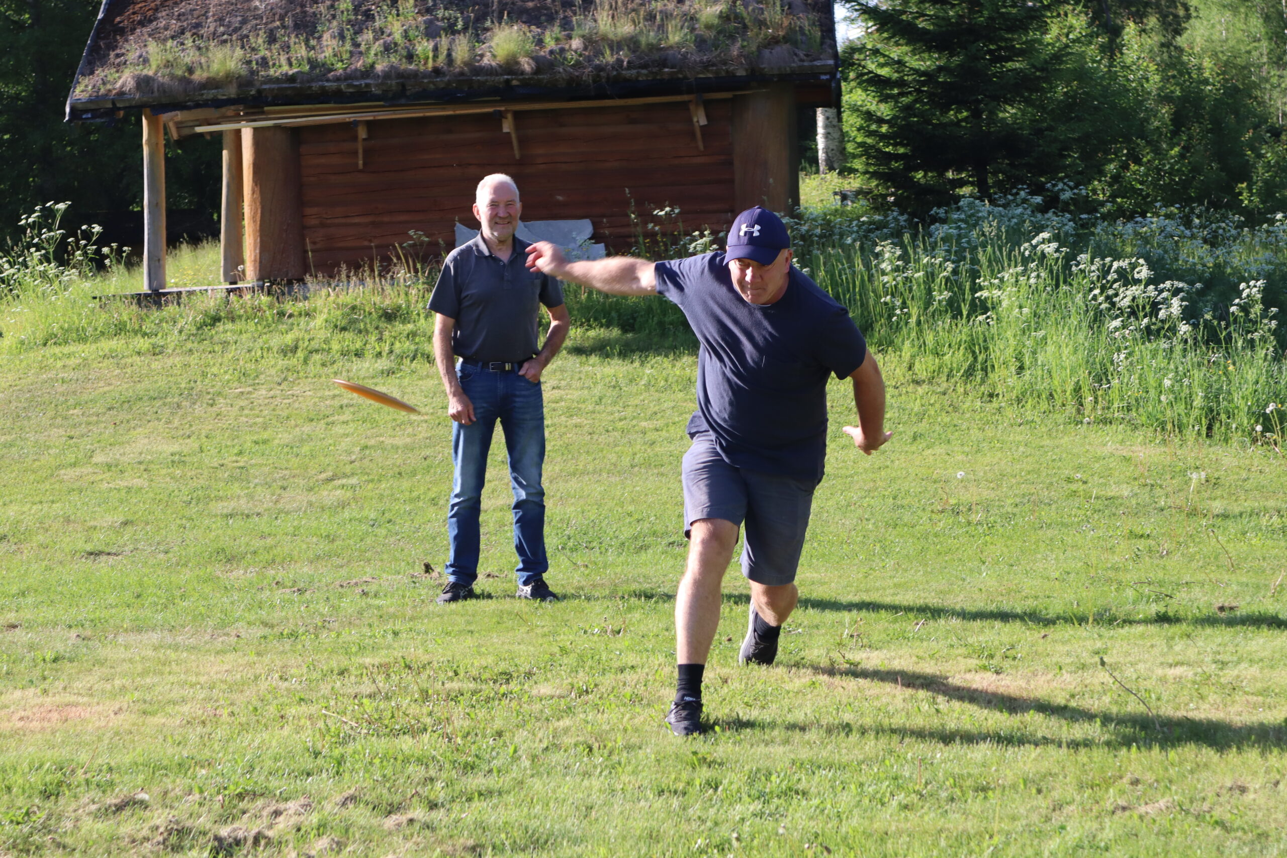 Hans Petter Bråthen prøver å få teken på frisbeen mens Per Håkon Gusterud ser på i bakgrunnen.