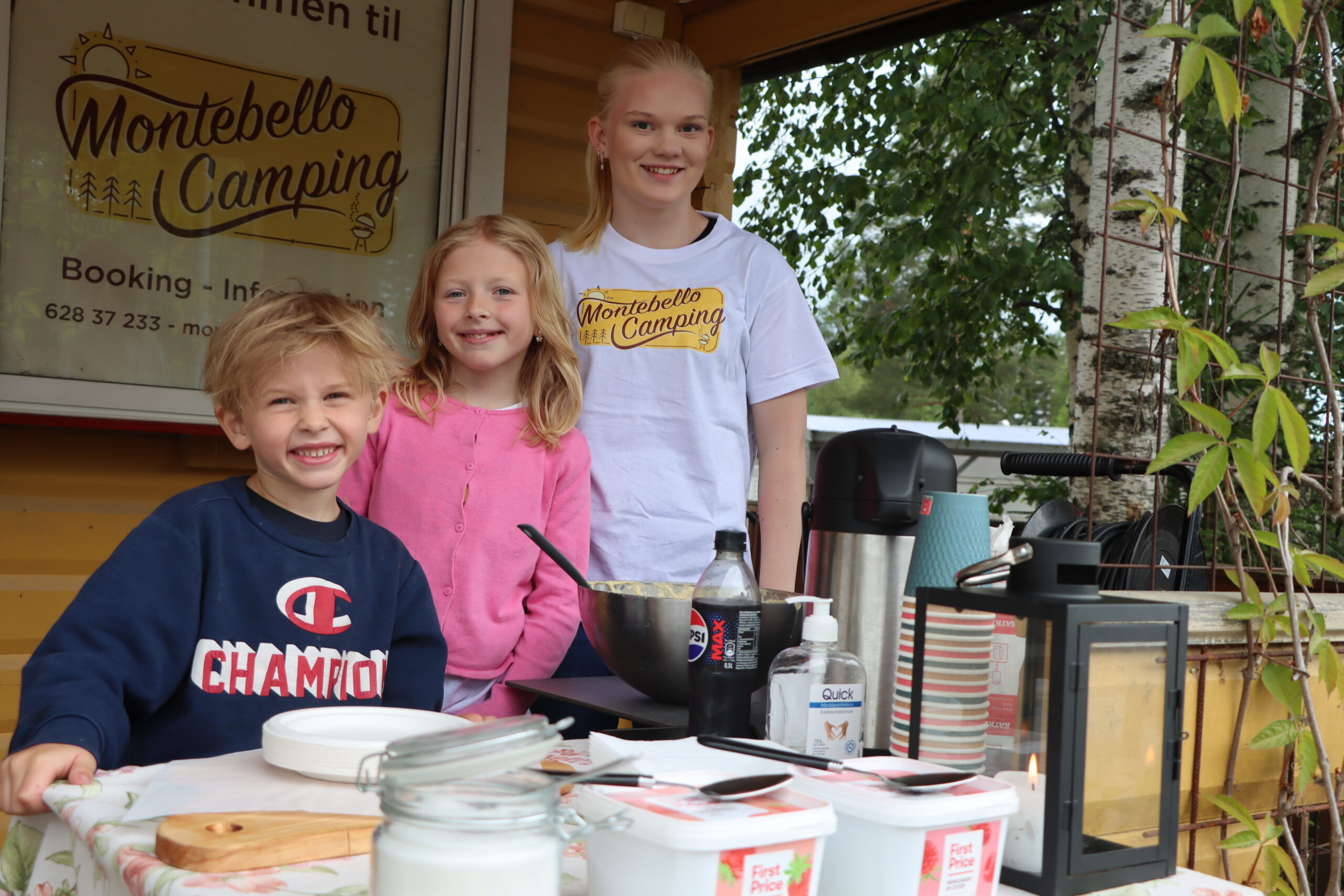 Mats Albert Amundsen (6) (f.v.), Ingrid Fredrikke Amundsen (10) og Nora Bonnerud Askerud (14) selger vafler og kaffe til gjestene på campingen.