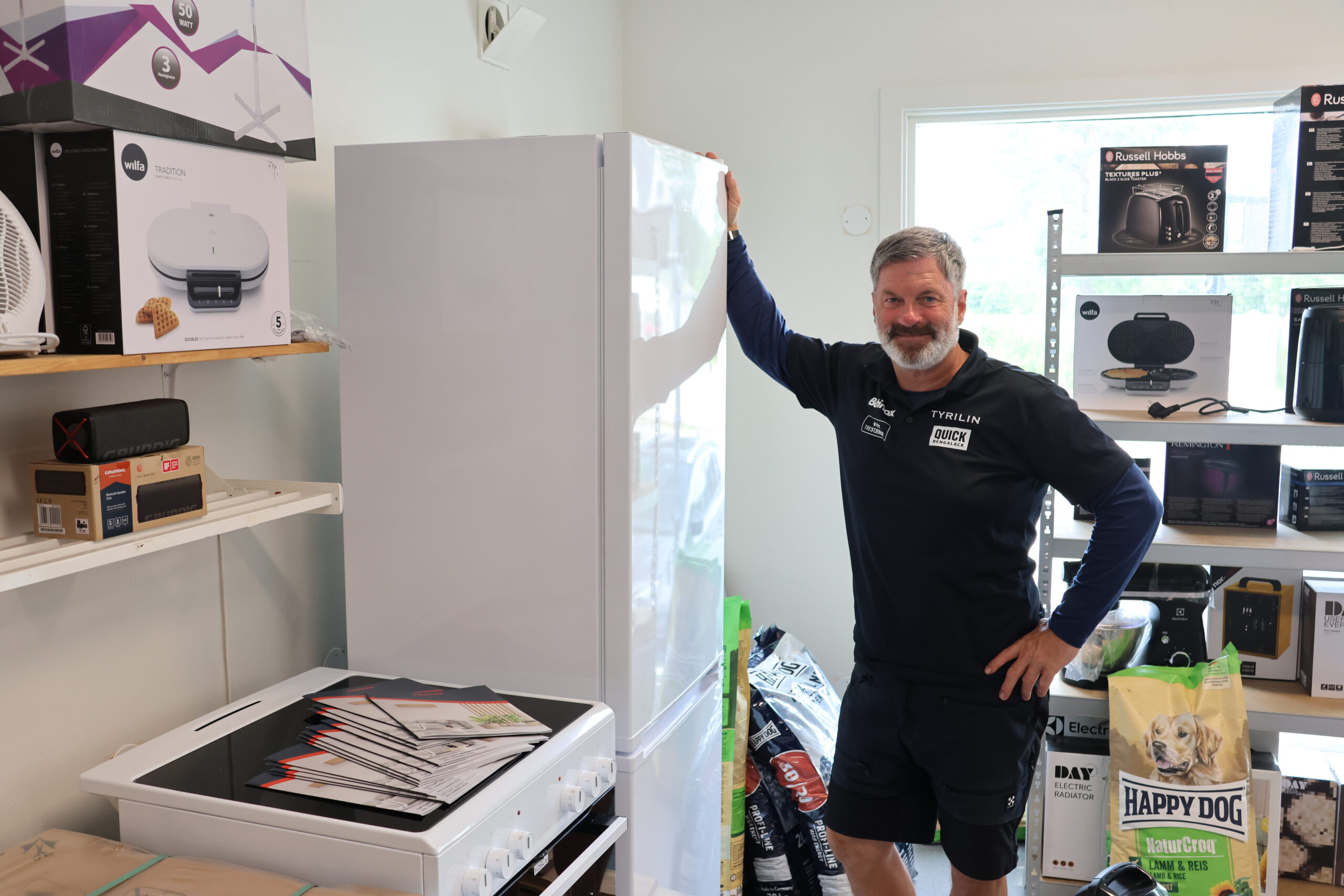 Hvitevarer er en viktig del av vareutvalget til Sport & Farve og her viser Arne Ekstrand frem noe av utvalget butikken fører.