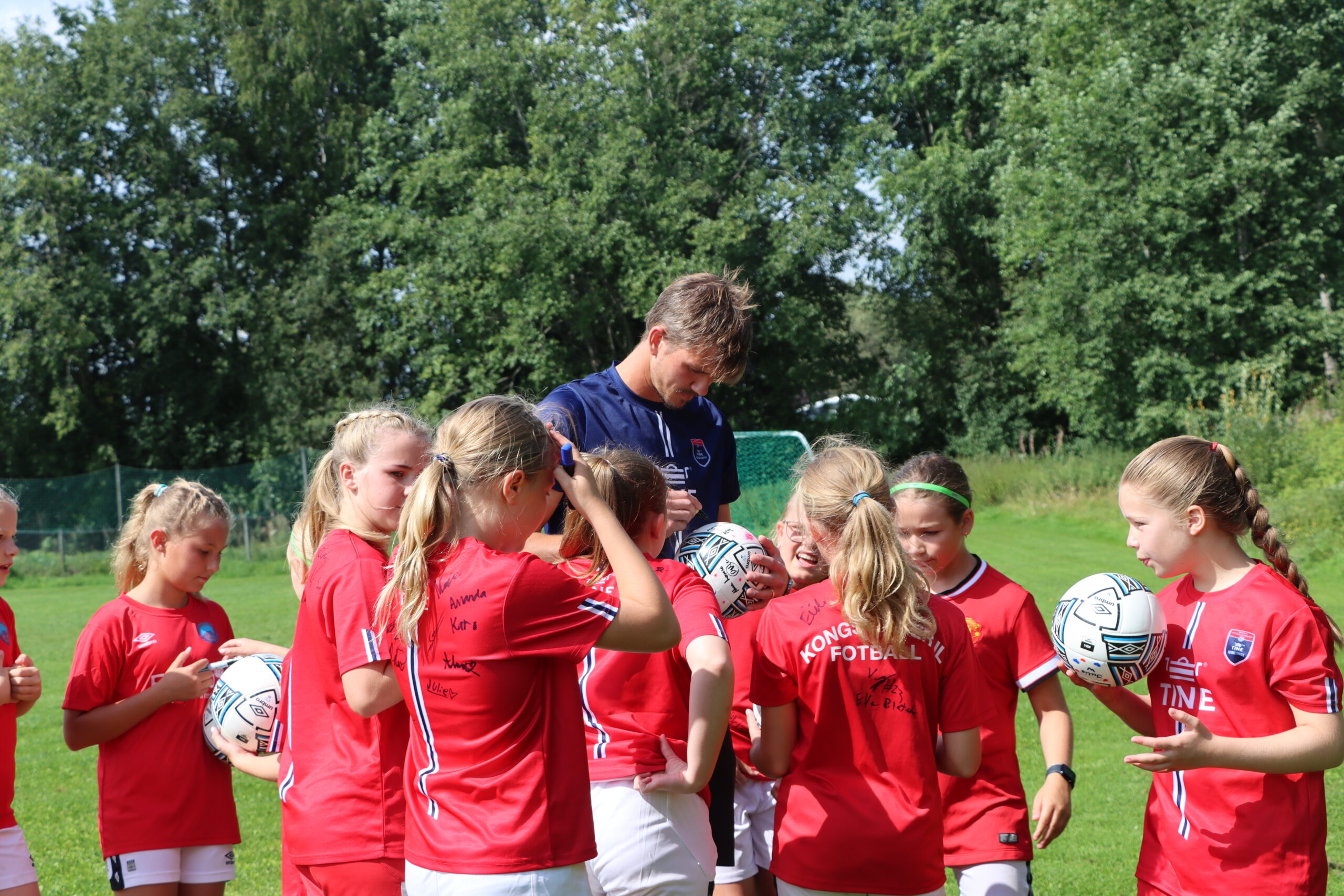 De unge fotballspillerene samlet på signaturer, både av hverandre og spillerne fra A-laget.