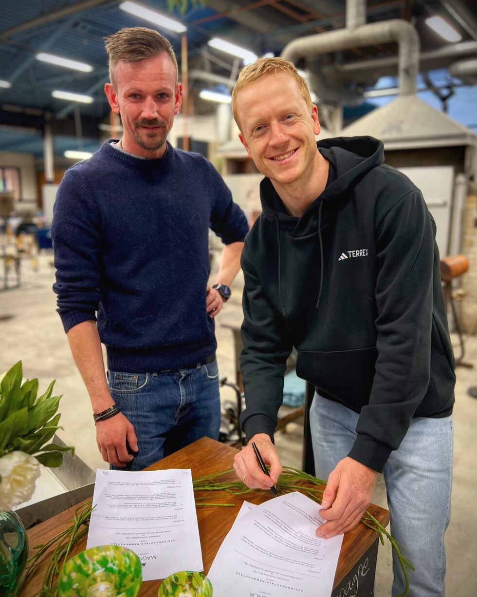 Fred Lund, driftsleder ved Magnor Glassverk og Johannes Thingnes Bø inngår samarbeid om ny premiekolleksjon.