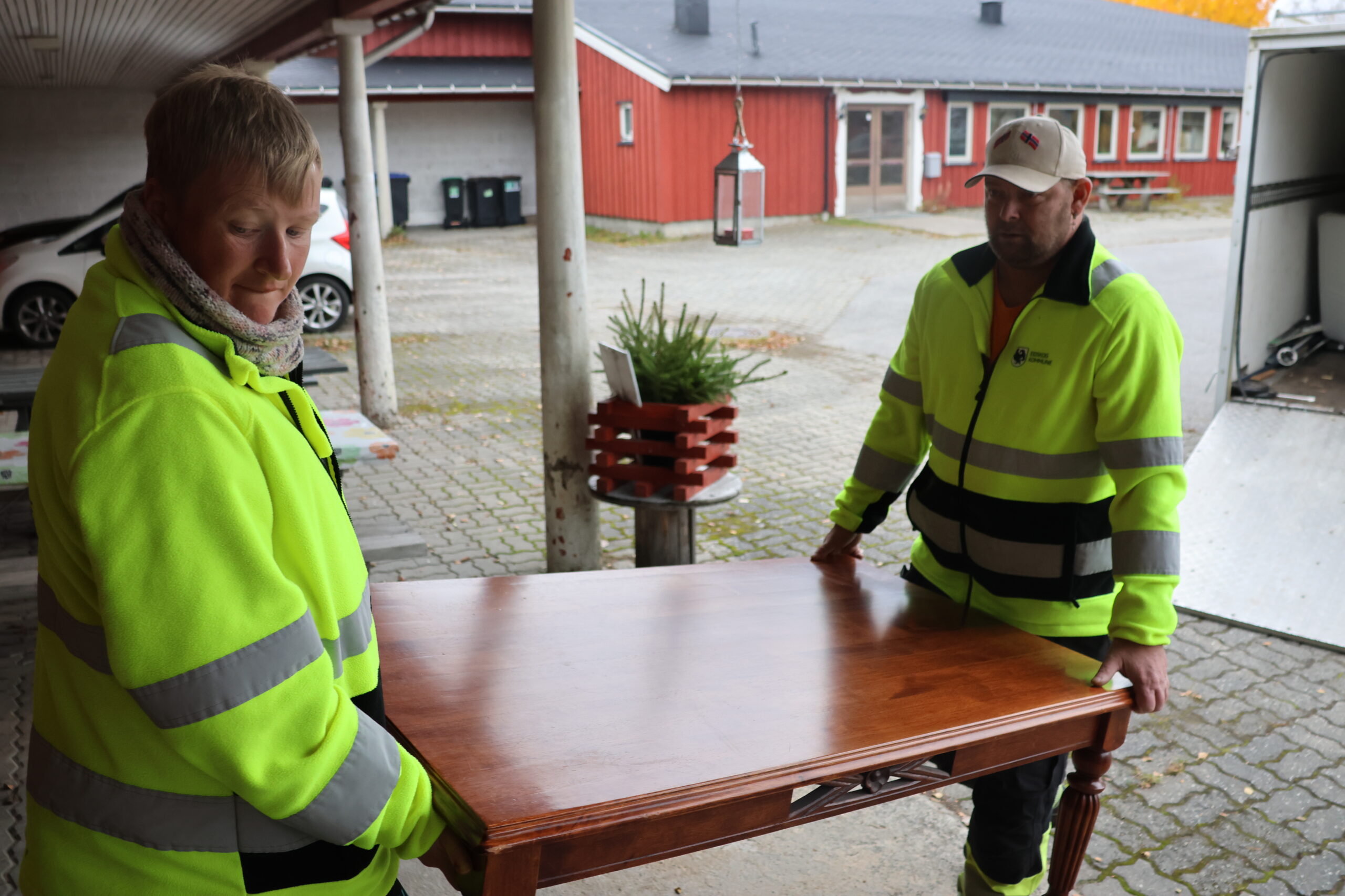 Marte MIcaelsen og Raymond Hovde bærer et bord inn på et lager på Tobøl. Det kan bli mange løft i løpet av en arbeidsdag.
