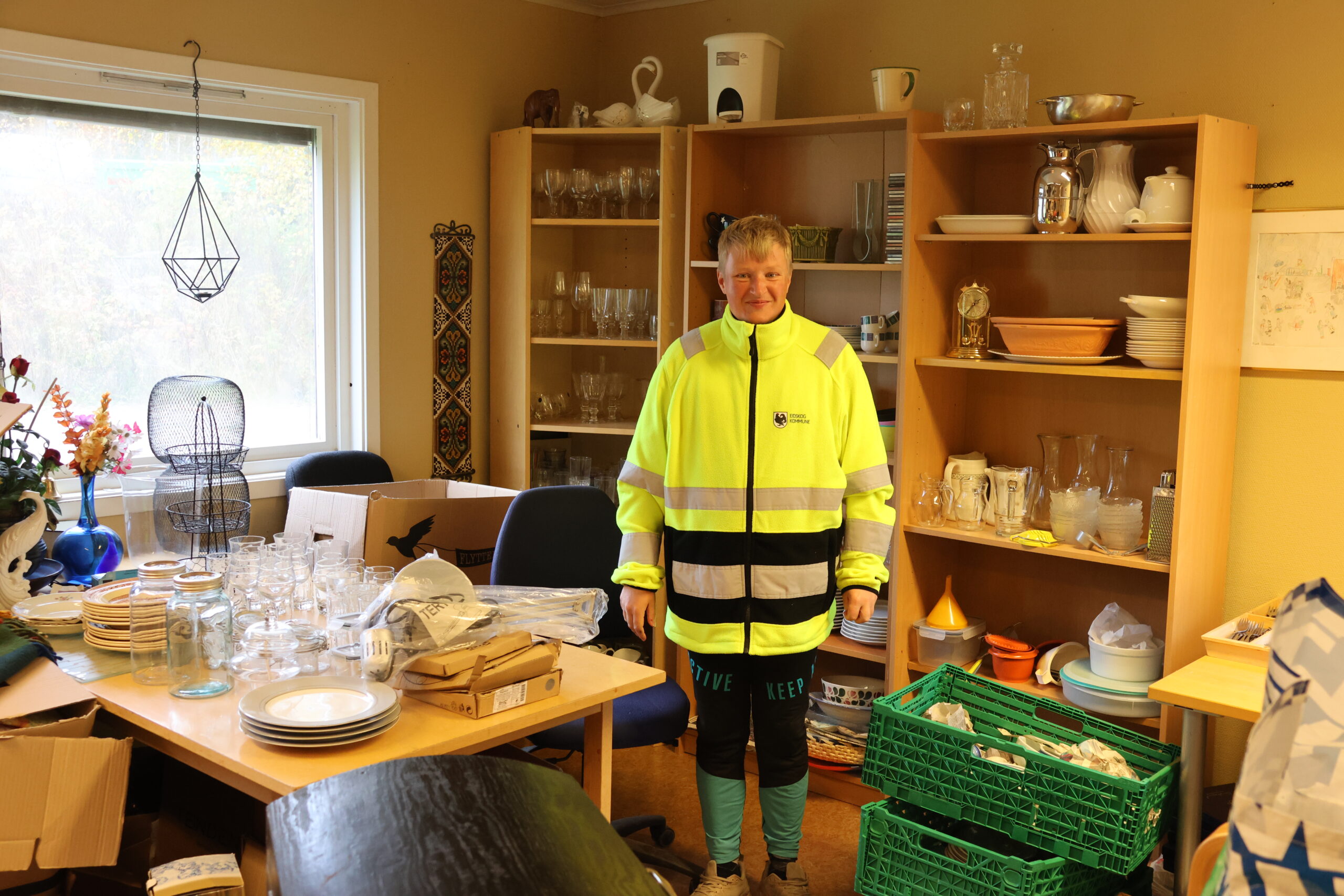 Marte Micaelsen viser frem rommet med det "rare i". Her har hun sortert og tatt vare på dekketøy, gardiner og annet de har fått av innbyggere og som kan brukes om igjen.
