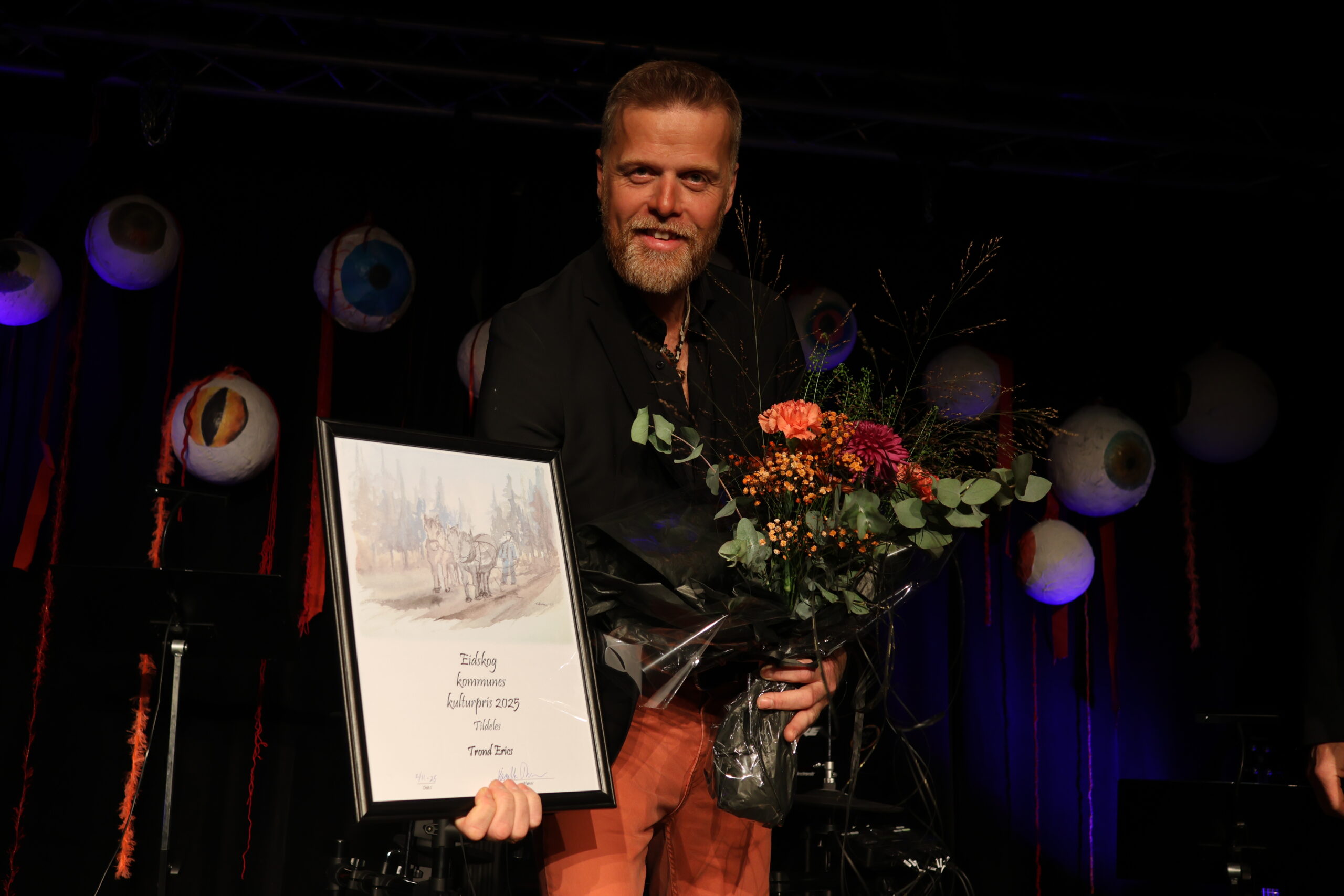Ole Kristian Ruud viser frem beviset for at Trond Erics har mottatt kommunens kulturpris.