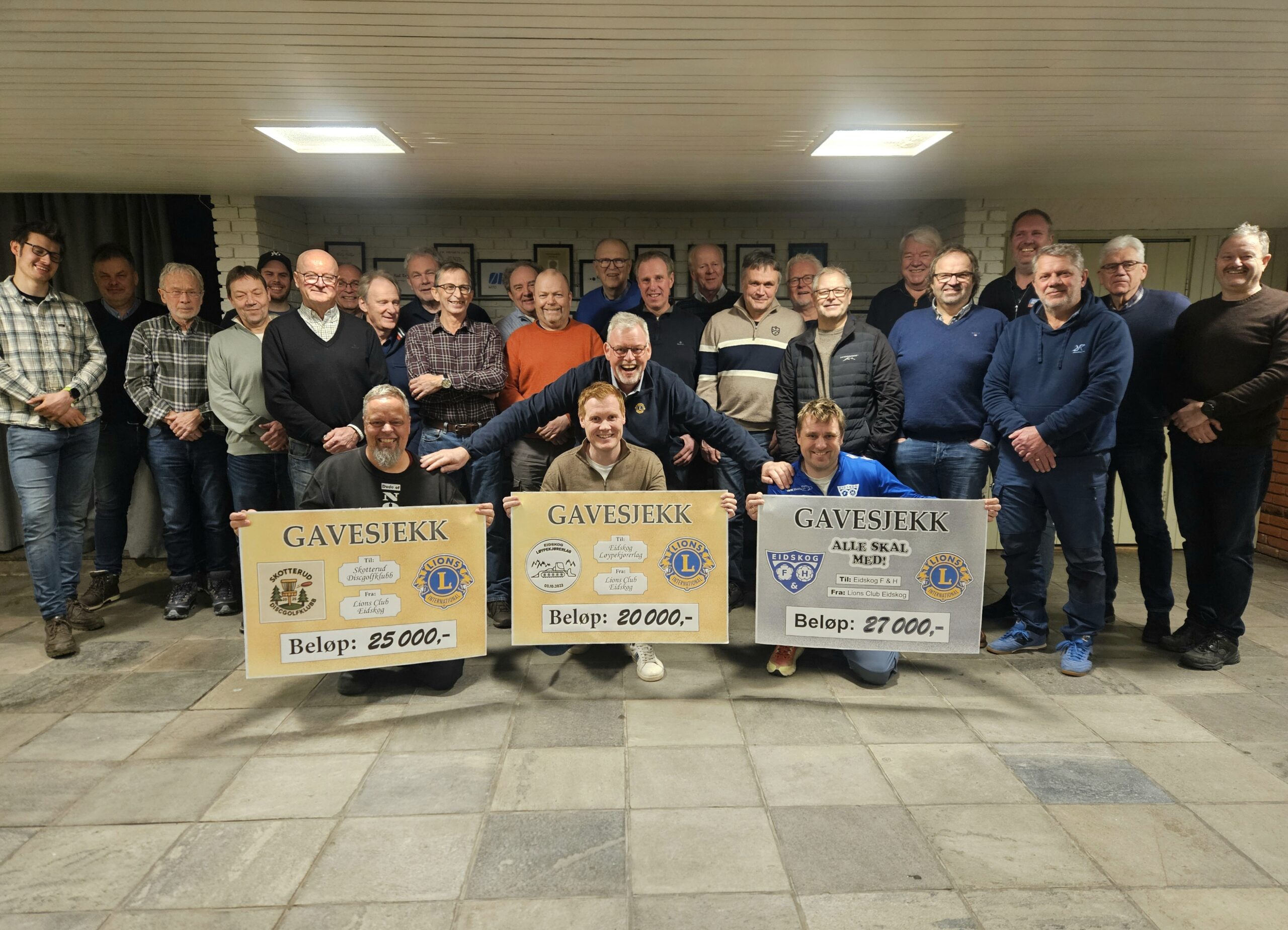 Medlemmene i Lions Club Eidskog sammen med takknemlige mottakere av pengegavene.