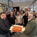 Kai Roger Lindberget (t.v.) og Pål-Erik Berntsen markerer sammen med kollegaer flyttingen med kake i de nye lokalene i Gågata.